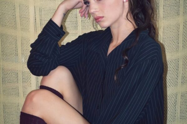 woman in black dress sitting on brown sofa